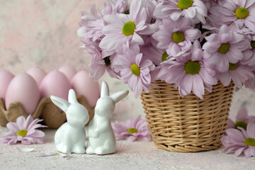Two porcelain bunnies, pink eggs a bouquet of flowers  