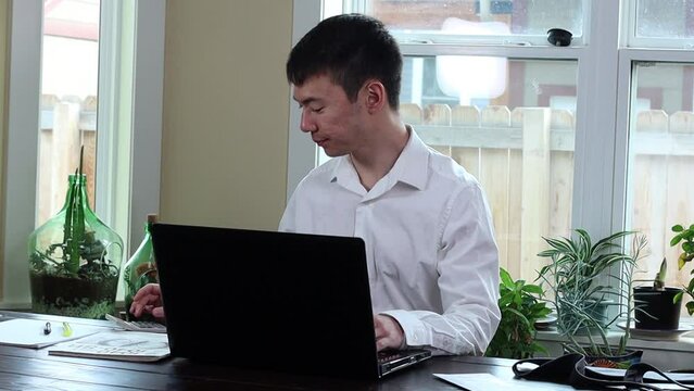 Doing online taxes at the kitchen table.  Stressful and focussed on the work.