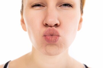Obraz premium portrait of a young woman on a white background with lips in the form of a kiss