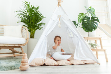 Little girl sitting in a wigwam at home © splitov27