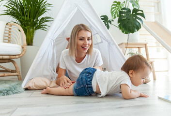 Young mother and little daughter spend time together in a wigwam at home © splitov27