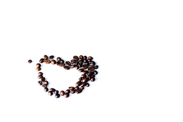 Roasted coffee beans in the shape of a heart on a white background