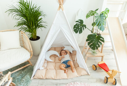Little baby girl sleeping in a wigwam at home