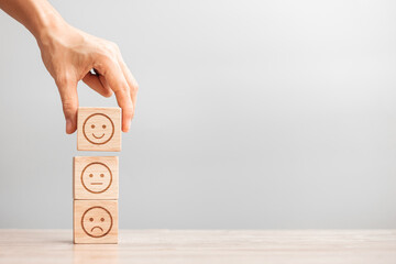 Man hand holding emotion face block. Customer choose Emoticon for user reviews. Service rating, ranking, customer review, satisfaction, evaluation and feedback concept