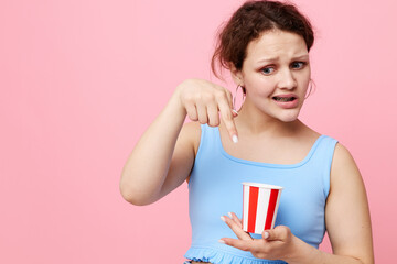 girl grimaces with a disposable glass fun pink background unaltered