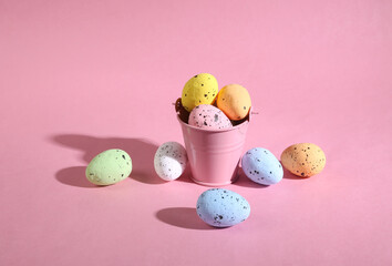 Mini bucket with colored Easter eggs on pink background. Easter minimal concept. Creative Happy Easter, spring layout.