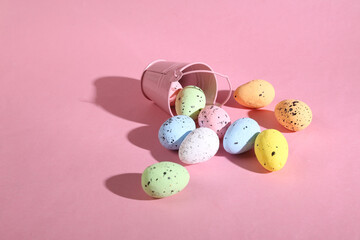 Mini bucket with colored Easter eggs on pink background. Easter minimal concept. Creative Happy Easter, spring layout.