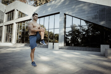 Fototapeta na wymiar Young athletic man doing warm-up before outdoor workout. Healthy lifestyle. Fitness concept