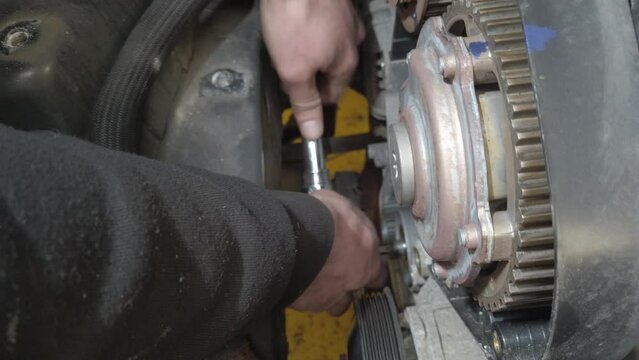A ratchet and extension being used to tighten a timing belt