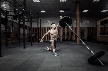 Obraz premium Athletic muscular man exercising with barbell in modern health club. Bodybuilding and Fitness