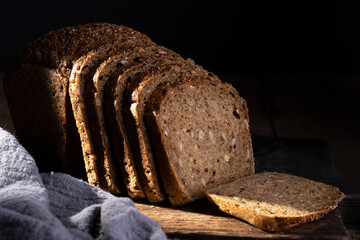 Bread, traditional homemade bread cut into slices on a rustic wooden background, close-up.
