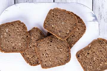 Sliced homemade bread on white wooden table. Top view.