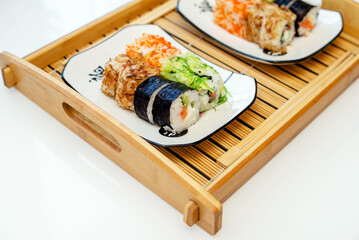 Several sushi on a white plate standing on a white background
