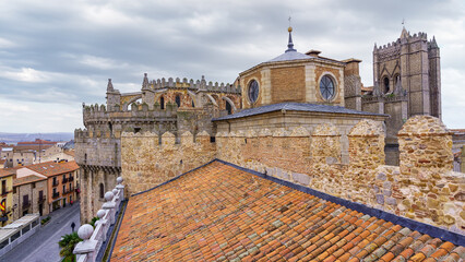 Aerial view of Avila Cathedral on a cloudy day with old tiled roofs.
