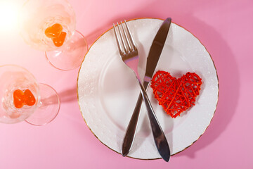 Valentine's day romantic dinner with red hearts on pink background.