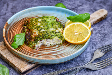 Fish bake refined with  spinach and gorgonzola cheese crust.White Code fish fillet stuffed  with broccoli  and  creamy Alfredo  sauce . Healthy food, delicious homemade italian  lunch .