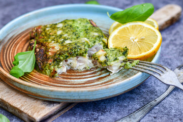 Fish bake refined with  spinach and gorgonzola cheese crust.White Code fish fillet stuffed  with broccoli  and  creamy Alfredo  sauce . Healthy food, delicious homemade italian  lunch .