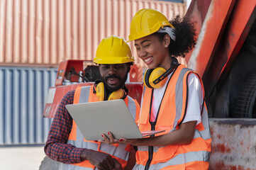 Engineering businessman and businesswoman holding laptop computer with container ship