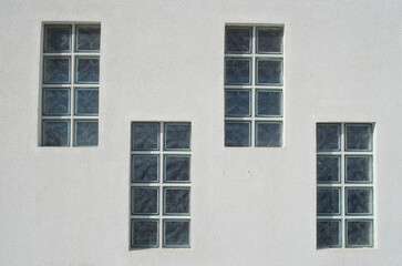 Four glass block windows looking outside on wall