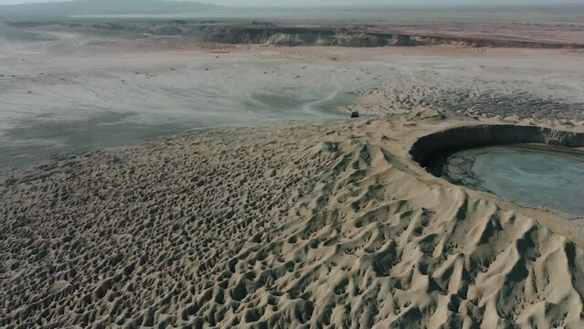 Aerial Circle Dolly Around Mud Volcano With Black 4x4 Parked On Side In Balochistan