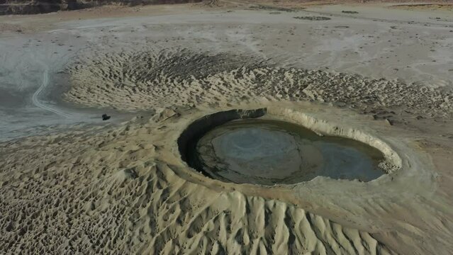 Aerial Circle Dolly Around Mud Volcano With Mud Pool In Crater. Slow Pedestal Up