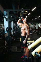 Portrait of healthy fitness man drinking protein shake. Athlete and professional certified trainer drinking sports nutrition beverage while working out
