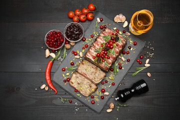 Traditional French terrine covered with bacon on dark wooden background with Christmas decorations