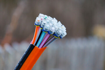 Colorful fiber optic cable ends with protective caps for communication lines protrude from the end...