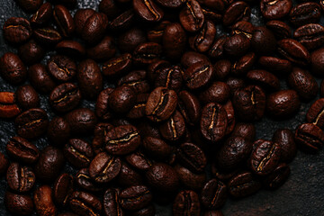 Roasted coffee beans close-up on a dark background. Colombian coffee