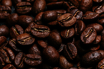 Roasted coffee beans close-up on a dark background. Colombian coffee