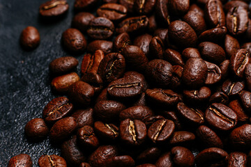 Roasted coffee beans close-up on a dark background. Colombian coffee