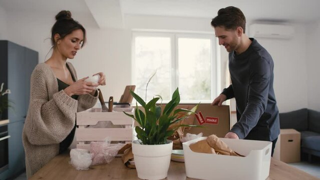 Caucasian couple unpacking some kitchen stuff in new house. Shot with RED helium camera in 8K.