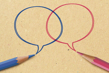 Blue and pink pencil with speech bubbles on recycled paper background - Concept of communication between men and women (gender communication)