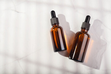 Amber glass bottles with dropper pipette with serum or essential oil on a white background....