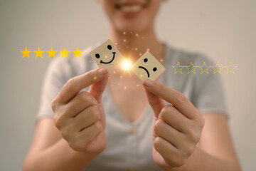 Asia woman using  for select smiley face icon for client evaluation and customer satisfaction after...