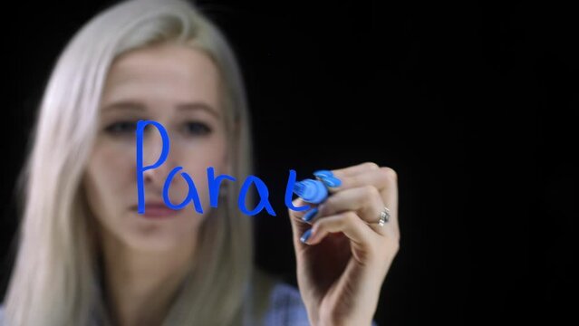 The word parathreads on a black background. The girl writes with a blue marker against the background of a black background.