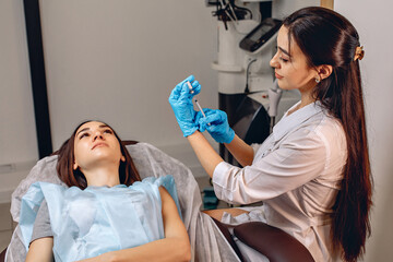 Fill the syringe with hyaluronic acid. The cosmetologist is preparing for the injection beauty...