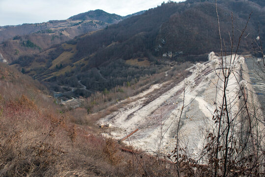 Barrier stopping the flow of copper and gold mining mining residuals into a settling basin, decantation lake