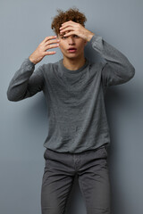 Attractive man in a gray sweatshirt fashion studio isolated background