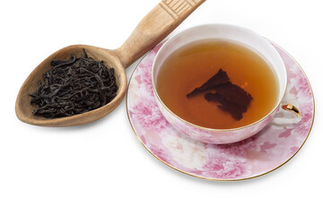 Cup of tea and dry tea leaves in wooden spoon
