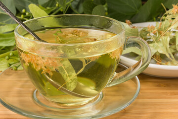 Cup of linden tea against the dried linden flowers closeup