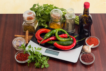 Chili on a kitchen scales, different spices, herbs, seasonings