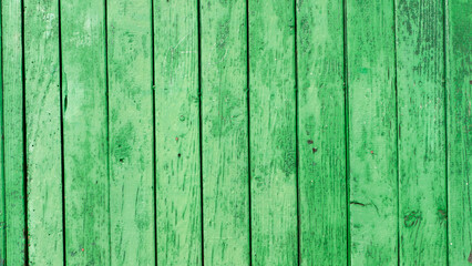 Puerta de tablones de madera pintado de verde con pintura manchada y deteriorada