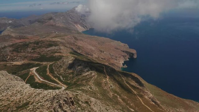 Beautiful landscape drone shot of in Greece on a rocky peak, Amorgos Island in cyclades Aegean Sea with beautiful panorama of blue ocean and mountains