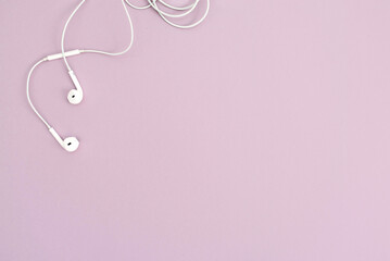 Minimalistic top view with white headphones on pastel background