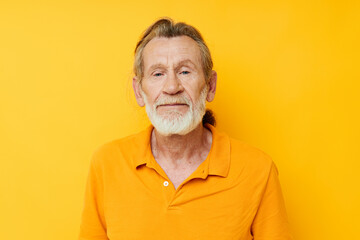 Obraz premium Portrait of happy senior man yellow shirt posing emotions yellow background