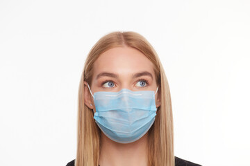 female face in a medical mask with eyes looks up