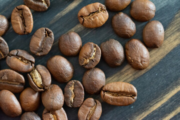 Kaffeebohnen auf einen schwarzen Holzuntergrund mit Musterung