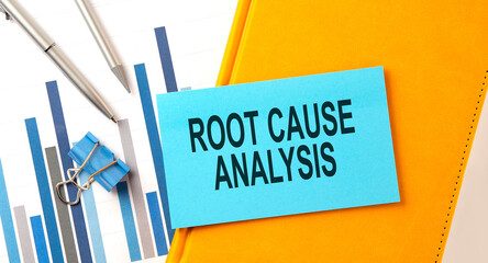 ROOT CAUSE ANALYSIS text on sticker on the yellow notebook with chart and pen