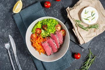 Salad with pieces of tuna and sesame with fresh vegetable salad on a plate. Authentic Japanese food. Top view